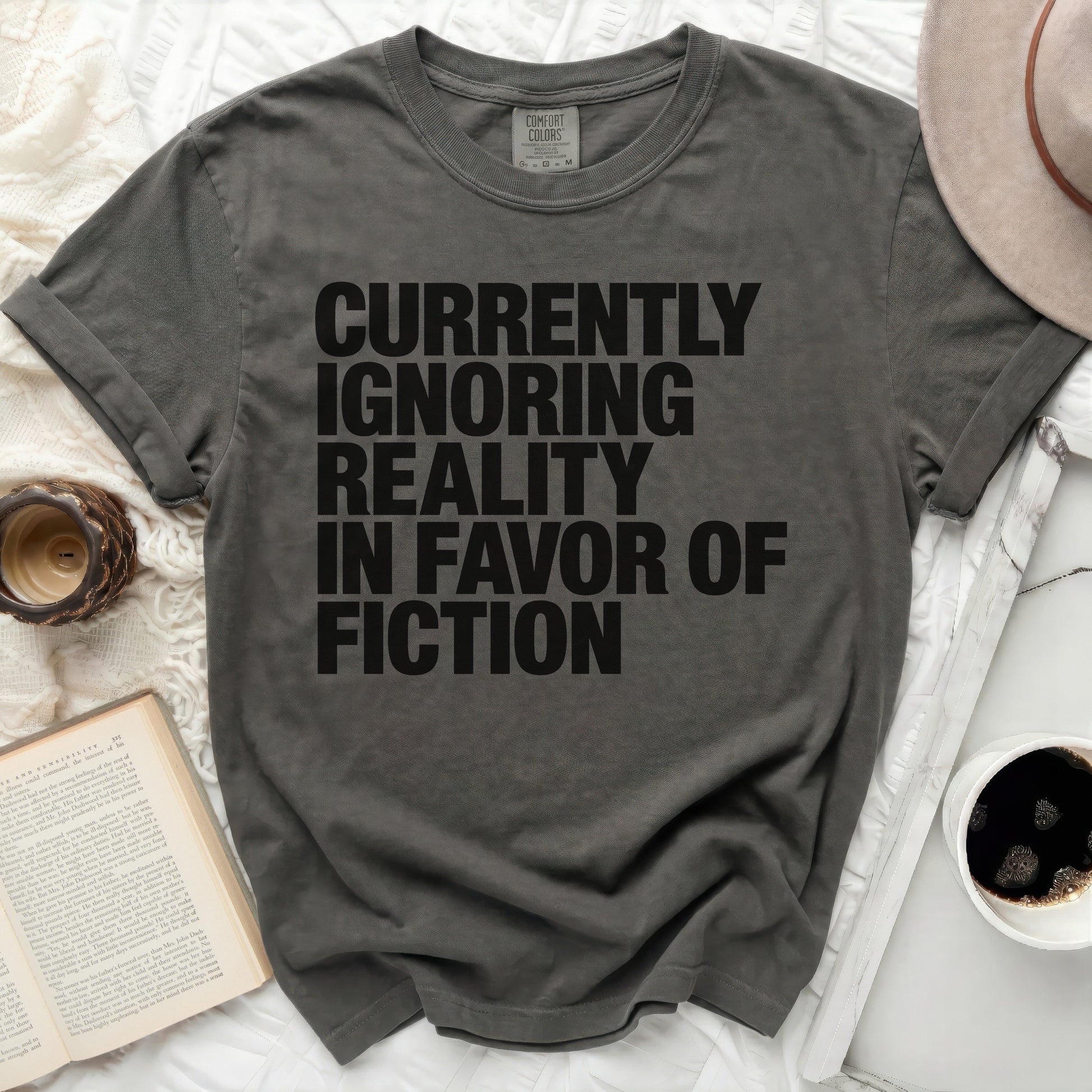 Charcoal t-shirt with "Currently Ignoring Reality In Favor Of Fiction" text.