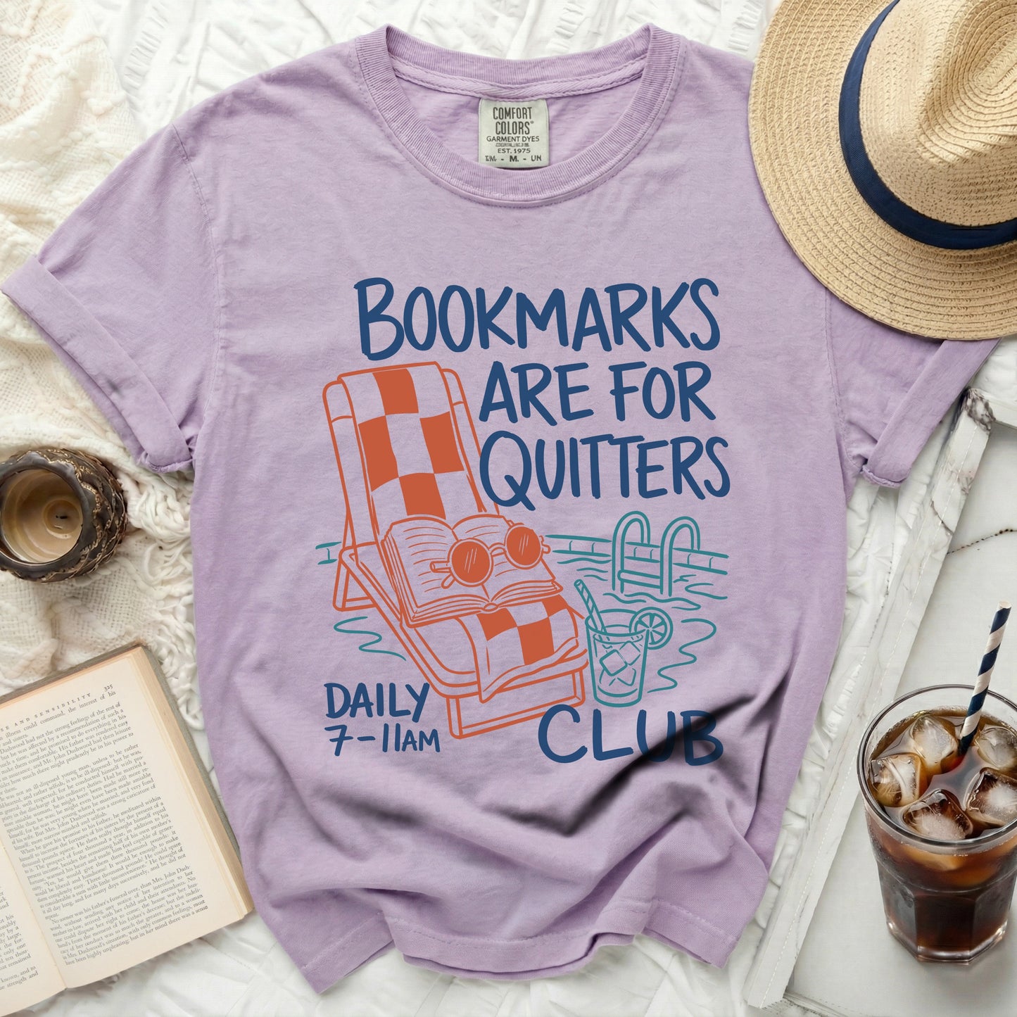 Purple t-shirt with "Bookmarks Are For Quitters" graphic and pool scene.