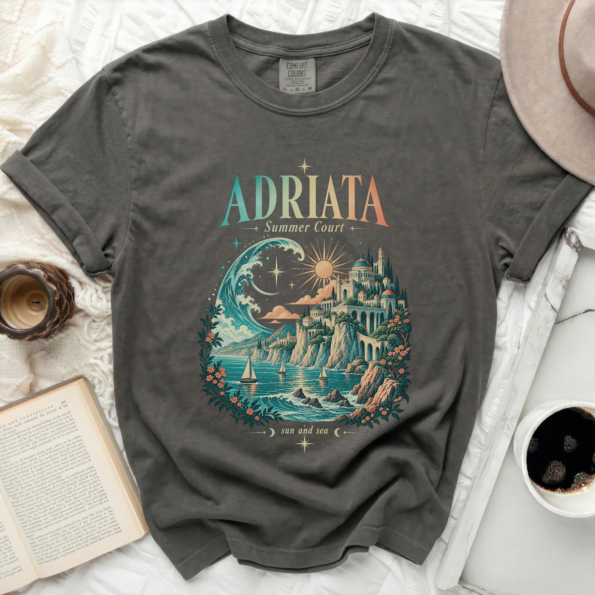 T-shirt with "ADRIATA Summer Court sun and sea" graphic featuring a coastal town and ocean scene.