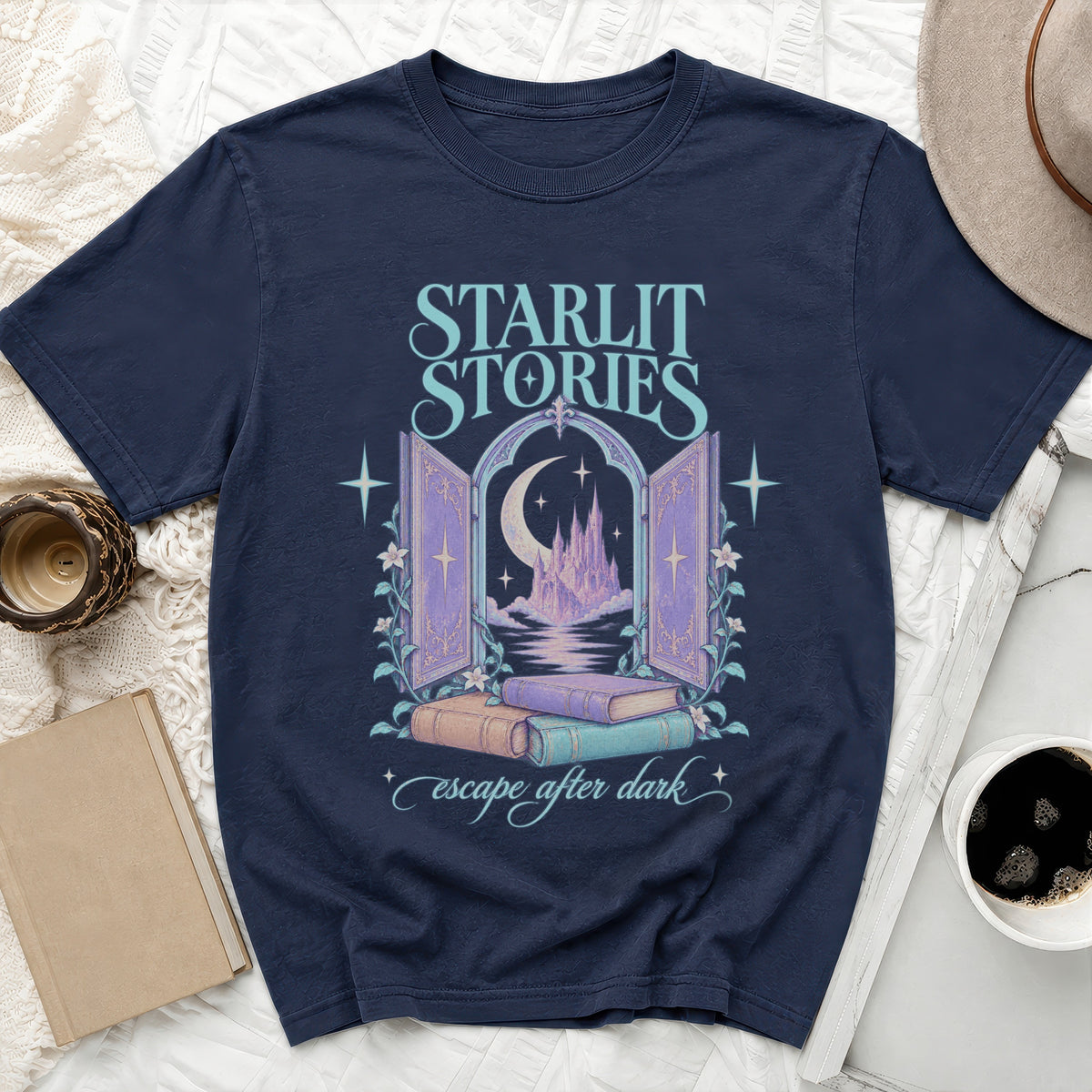 Dark t-shirt with "Starlit Stories escape after dark" text and castle graphic.