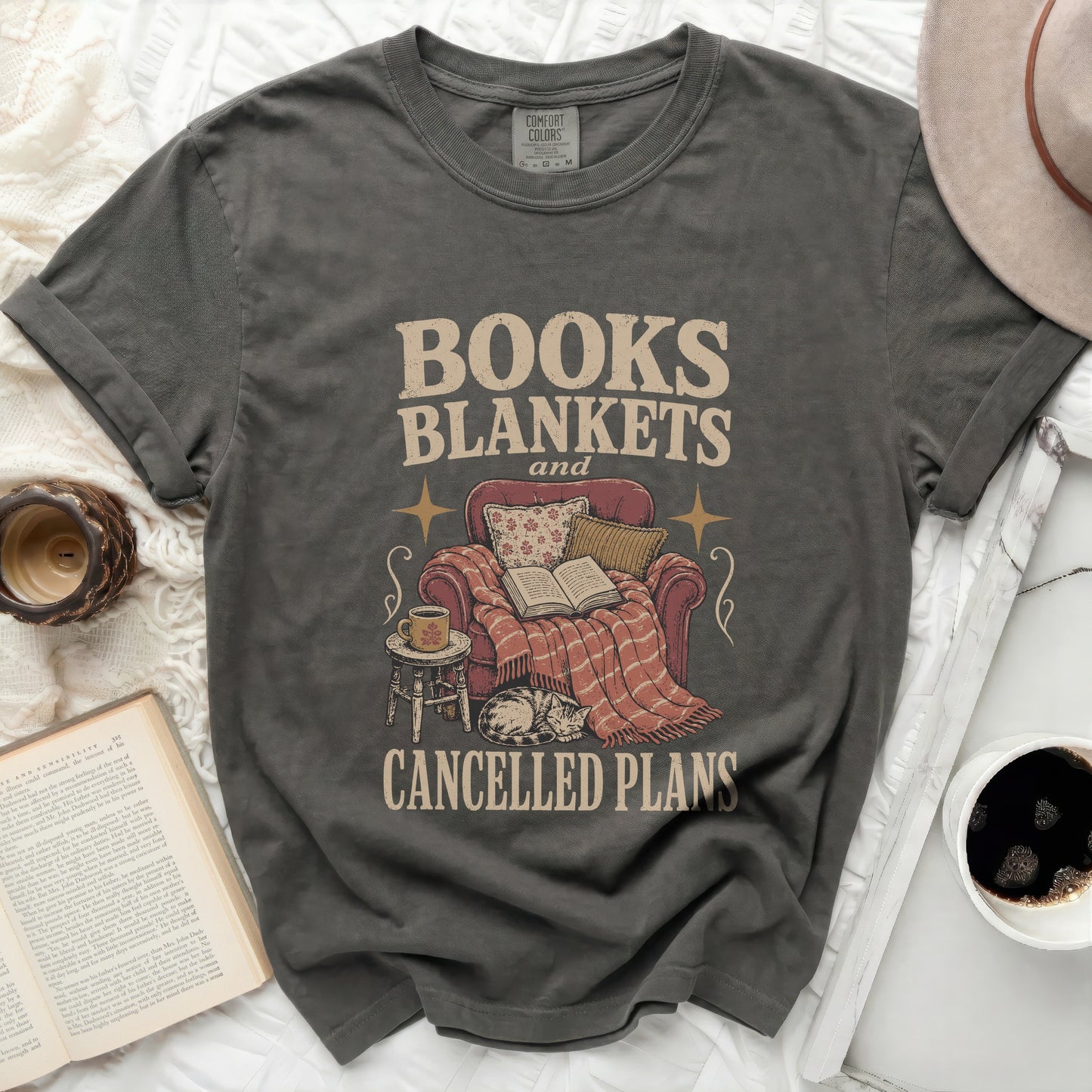 Gray t-shirt with "BOOKS BLANKETS and CANCELLED PLANS" text and illustration.