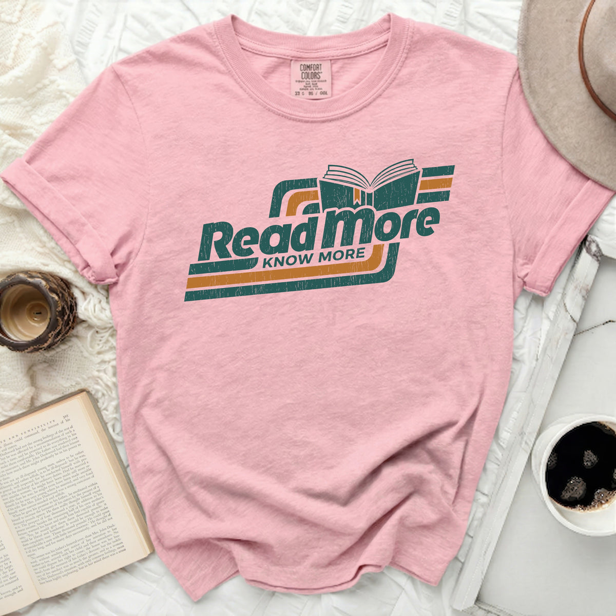 Pink t-shirt with "Read more KNOW MORE" graphic and an open book.