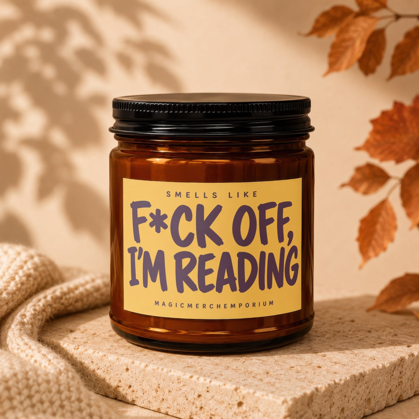 Amber candle with a yellow label that reads "F*ck off, I'm reading."