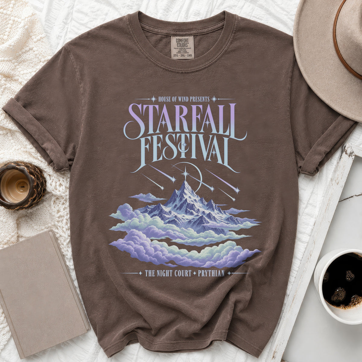 Brown t-shirt with "Starfall Festival" graphic, mountains, clouds, and text.