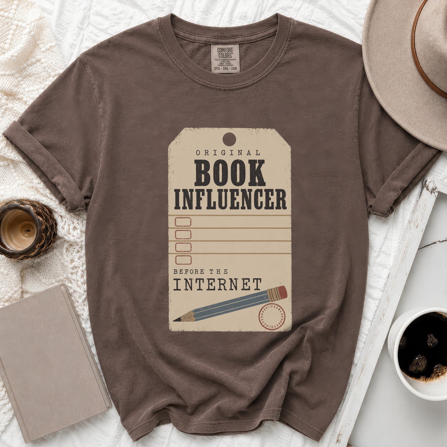 Brown t-shirt with "Original Book Influencer Before The Internet" graphic and pencil.