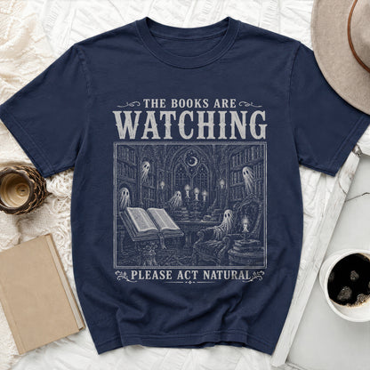 Navy t-shirt with "The Books Are Watching" and a spooky library scene.