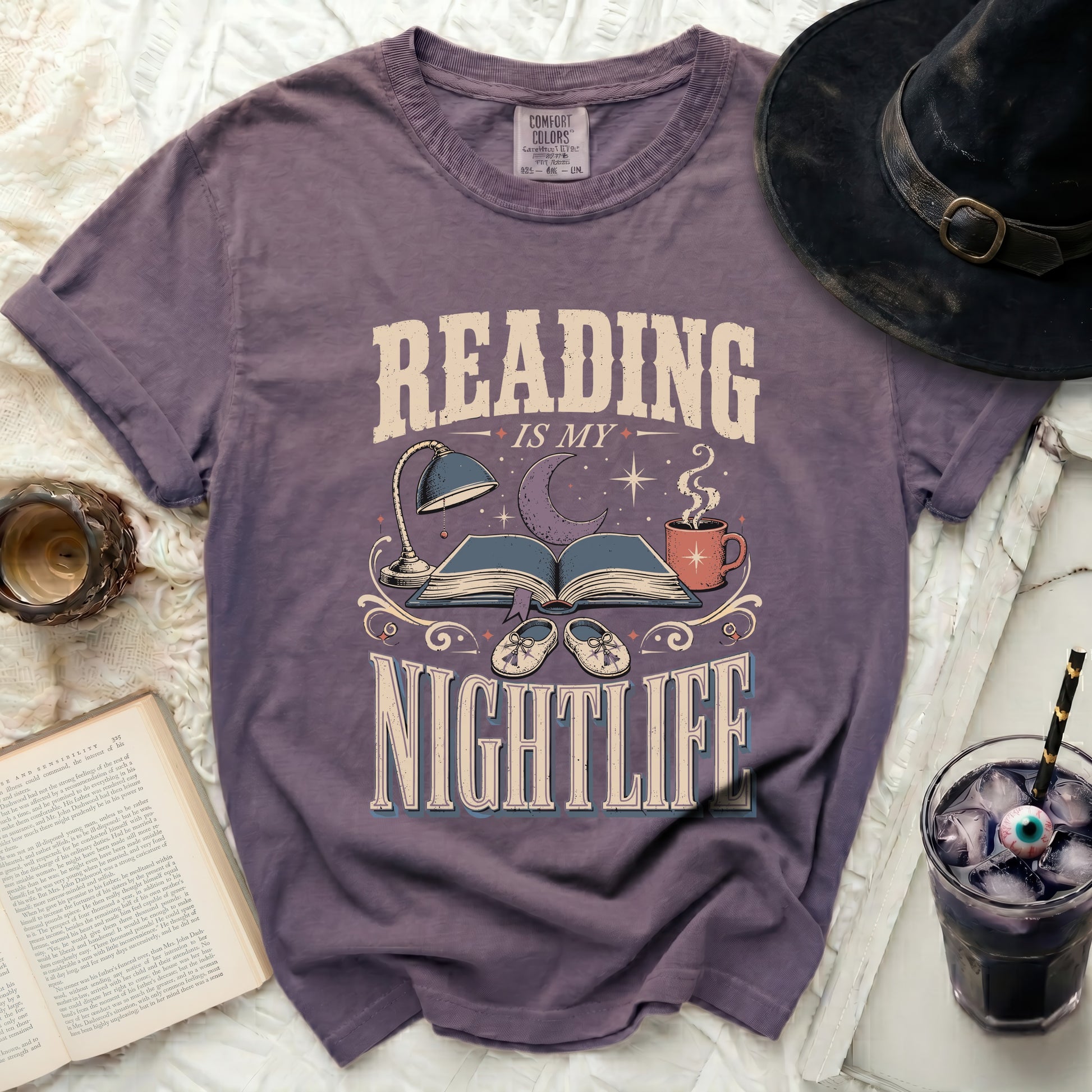 Purple t-shirt with graphic text "READING IS MY NIGHTLIFE" and book illustration.