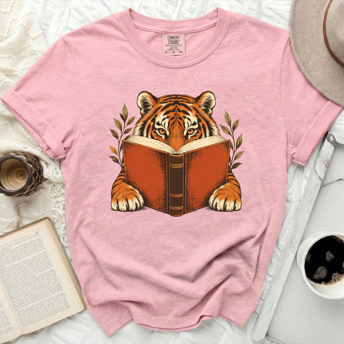 Pink t-shirt with a graphic of a tiger reading a book.