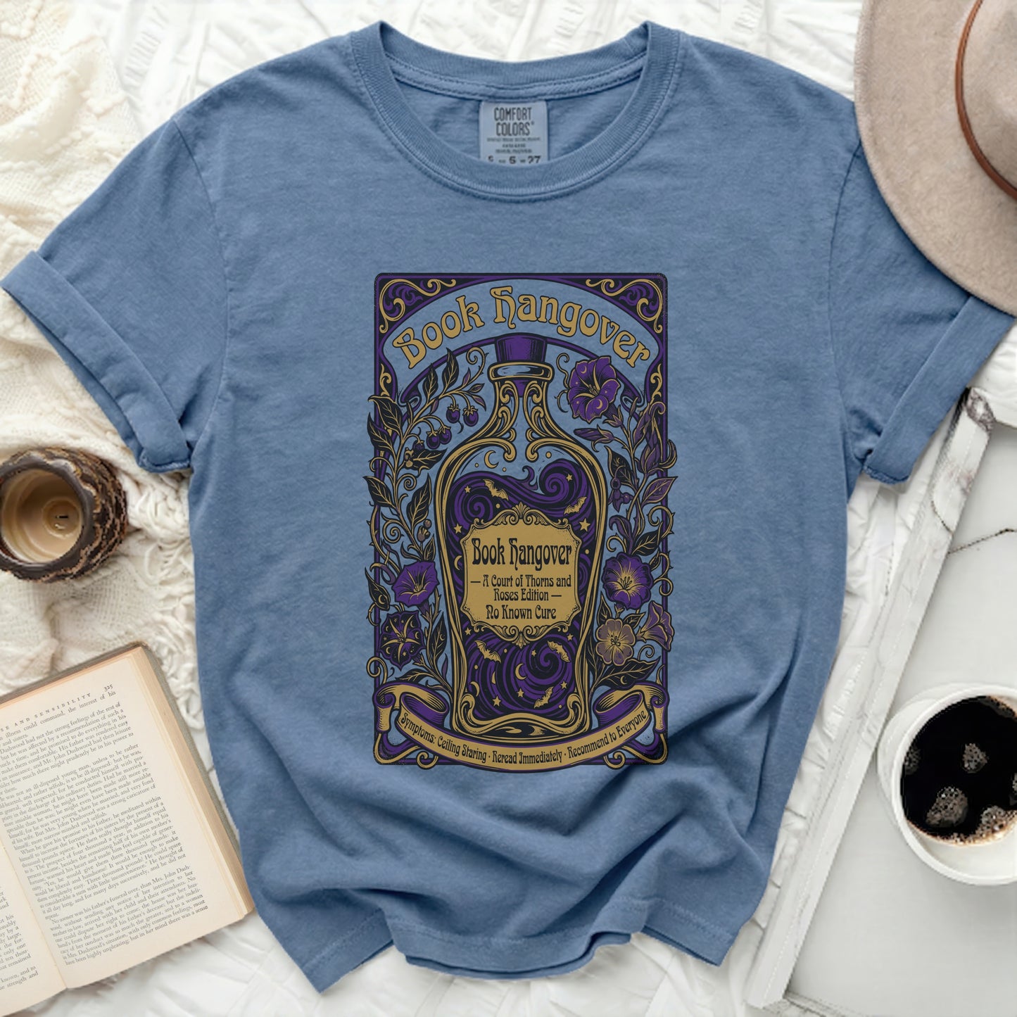 Blue t-shirt with "Book Hangover" text and a purple and gold potion bottle design.