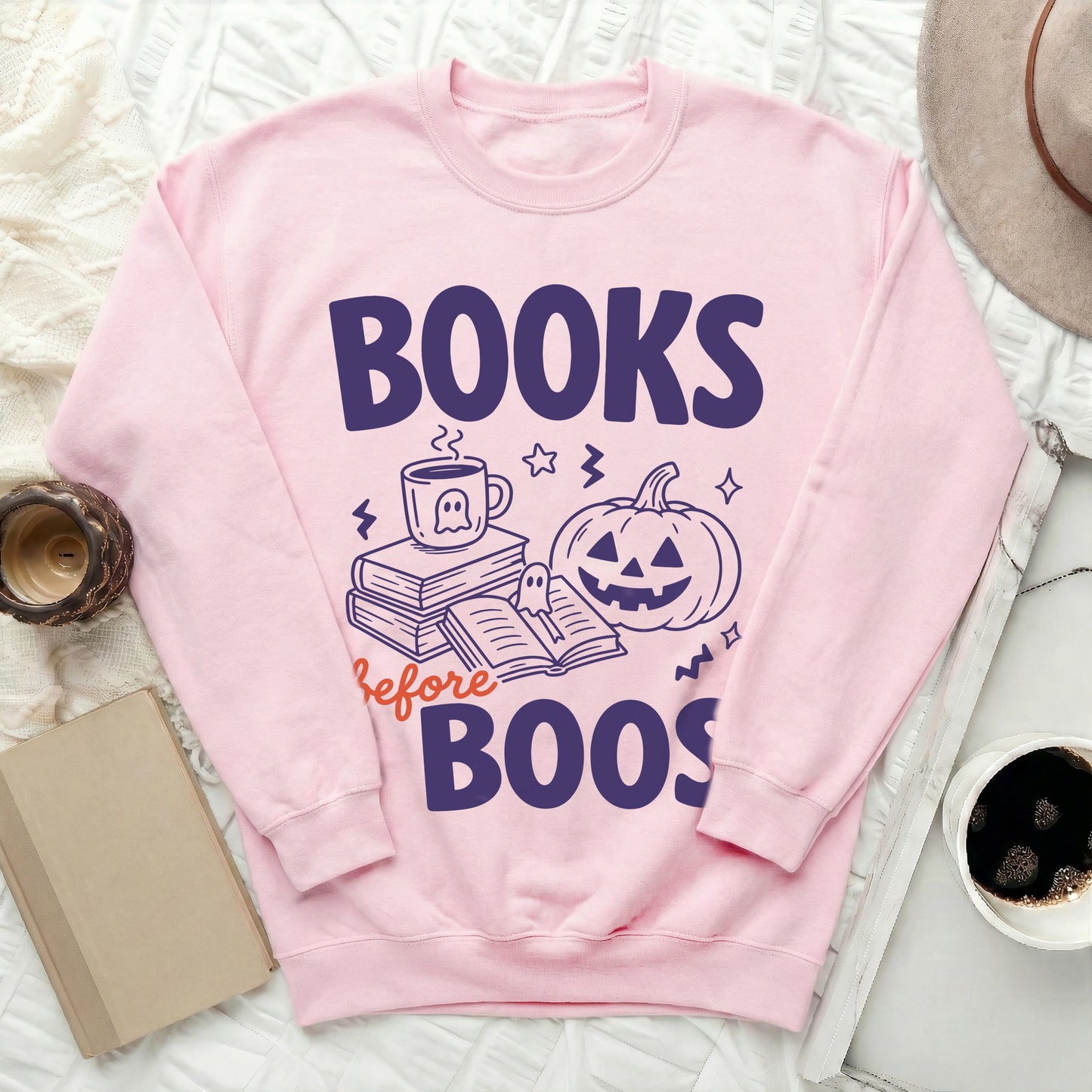 Pink sweatshirt with "Books Before Boos" graphic featuring books, a mug, and a pumpkin.