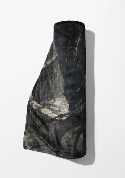 Rolled blanket with dark camouflage pattern against a white background.