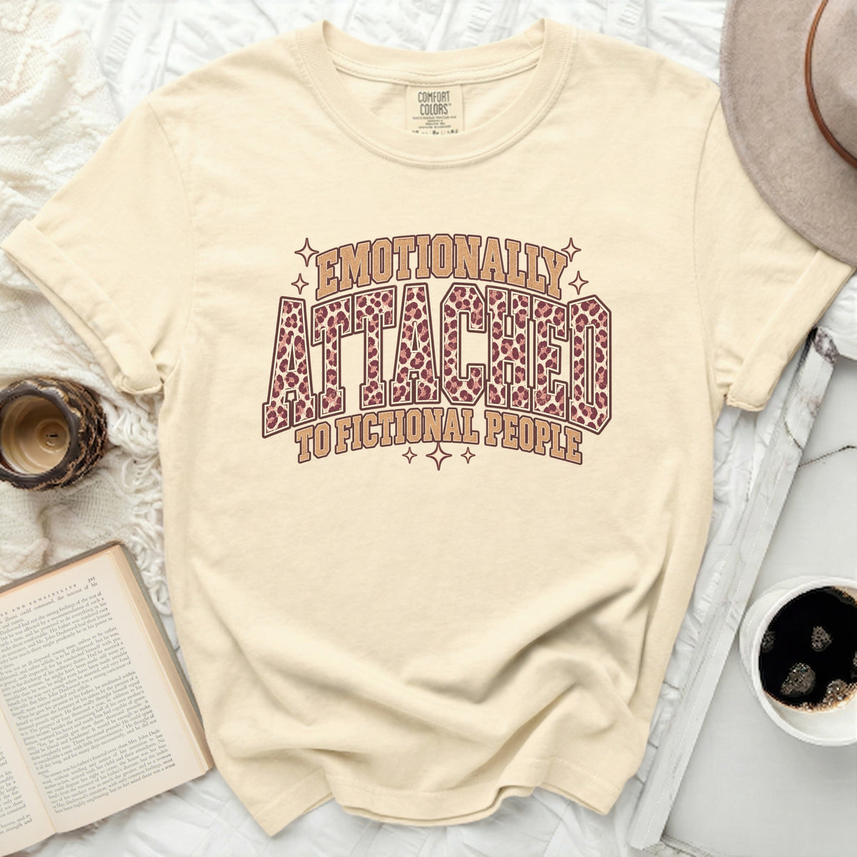 Cream t-shirt with "Emotionally Attached to Fictional People" text and leopard print.