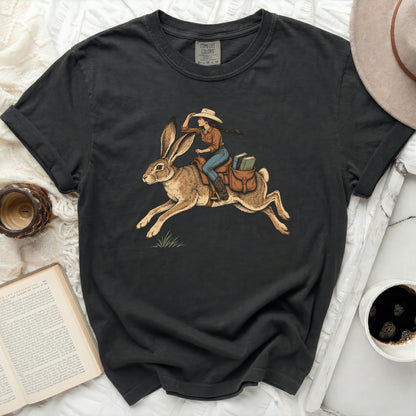 T-shirt with graphic of woman in cowboy hat riding a rabbit with books.