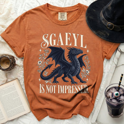Orange t-shirt with a black dragon and text "SGAEYL IS NOT IMPRESSED".