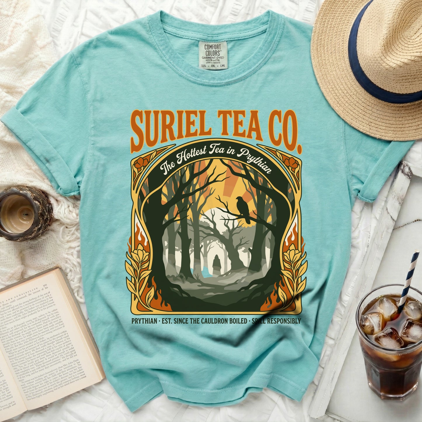 Teal t-shirt with "Suriel Tea Co." and a forest scene with text.