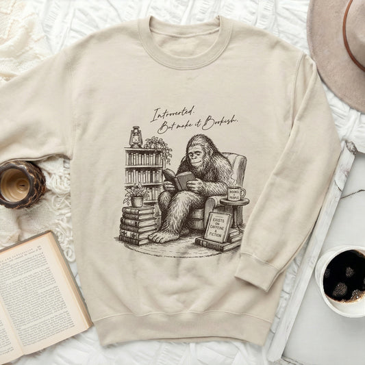 Bigfoot reading book with text "Introverted. But make it Bookish." on sweatshirt.