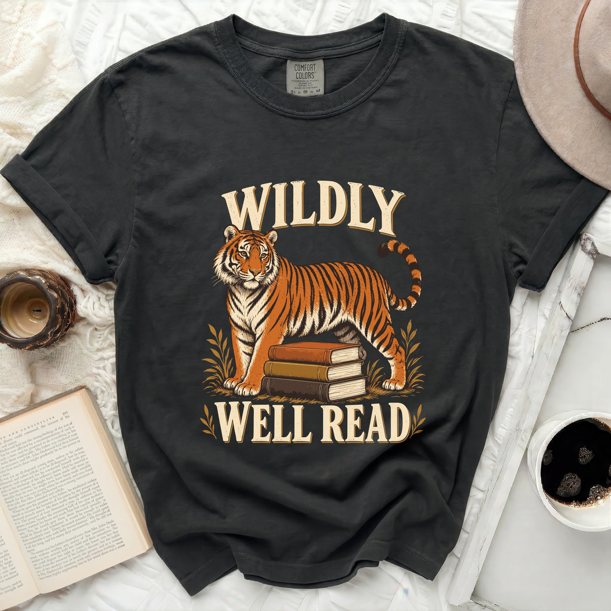 Black t-shirt with a tiger standing on books, text "WILDLY WELL READ".