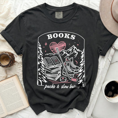 Dark t-shirt with "BOOKS pucks & slow burns" and heart graphic.