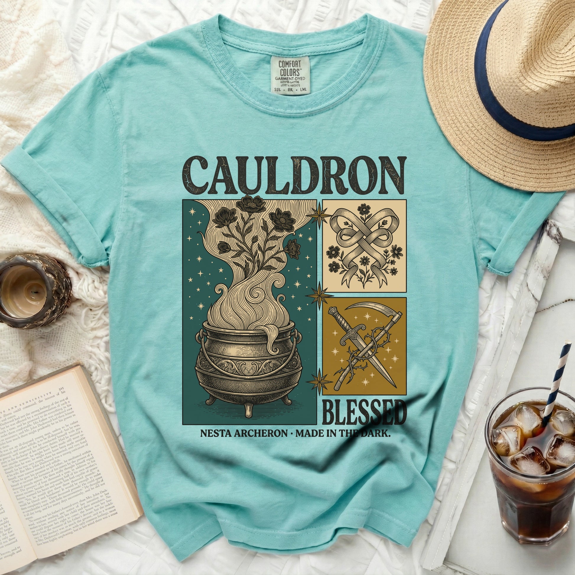 Aqua t-shirt with "CAULDRON BLESSED NESTA ARCHERON MADE IN THE DARK" graphic.