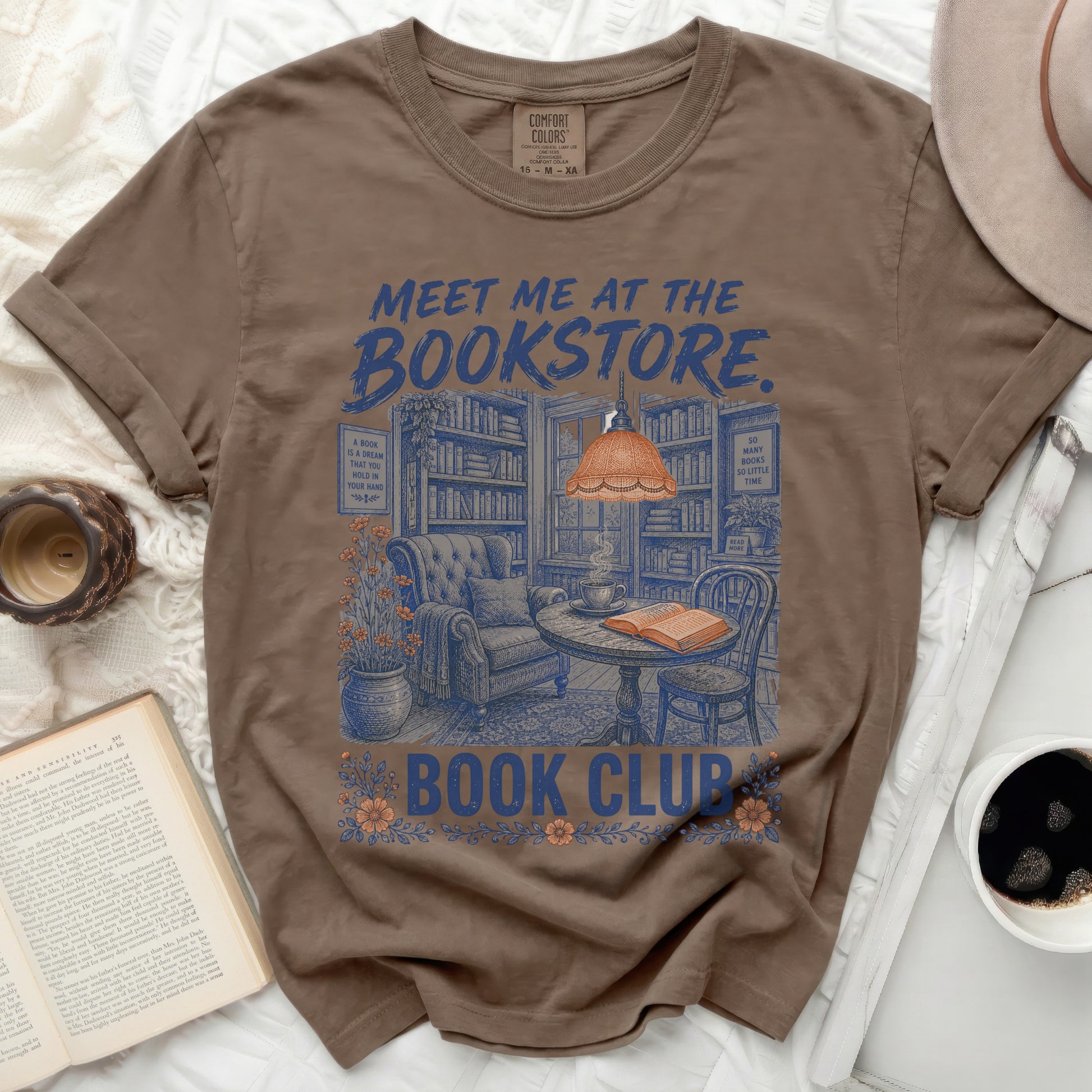 T-shirt with "Meet me at the Bookstore" and cozy reading nook graphic.