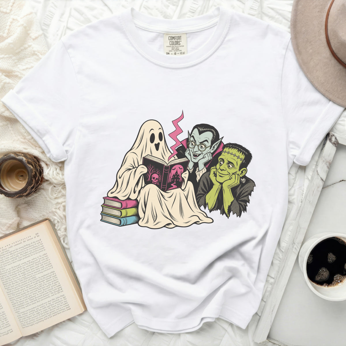 Ghost, vampire, and Frankenstein reading a book together on a white t-shirt.