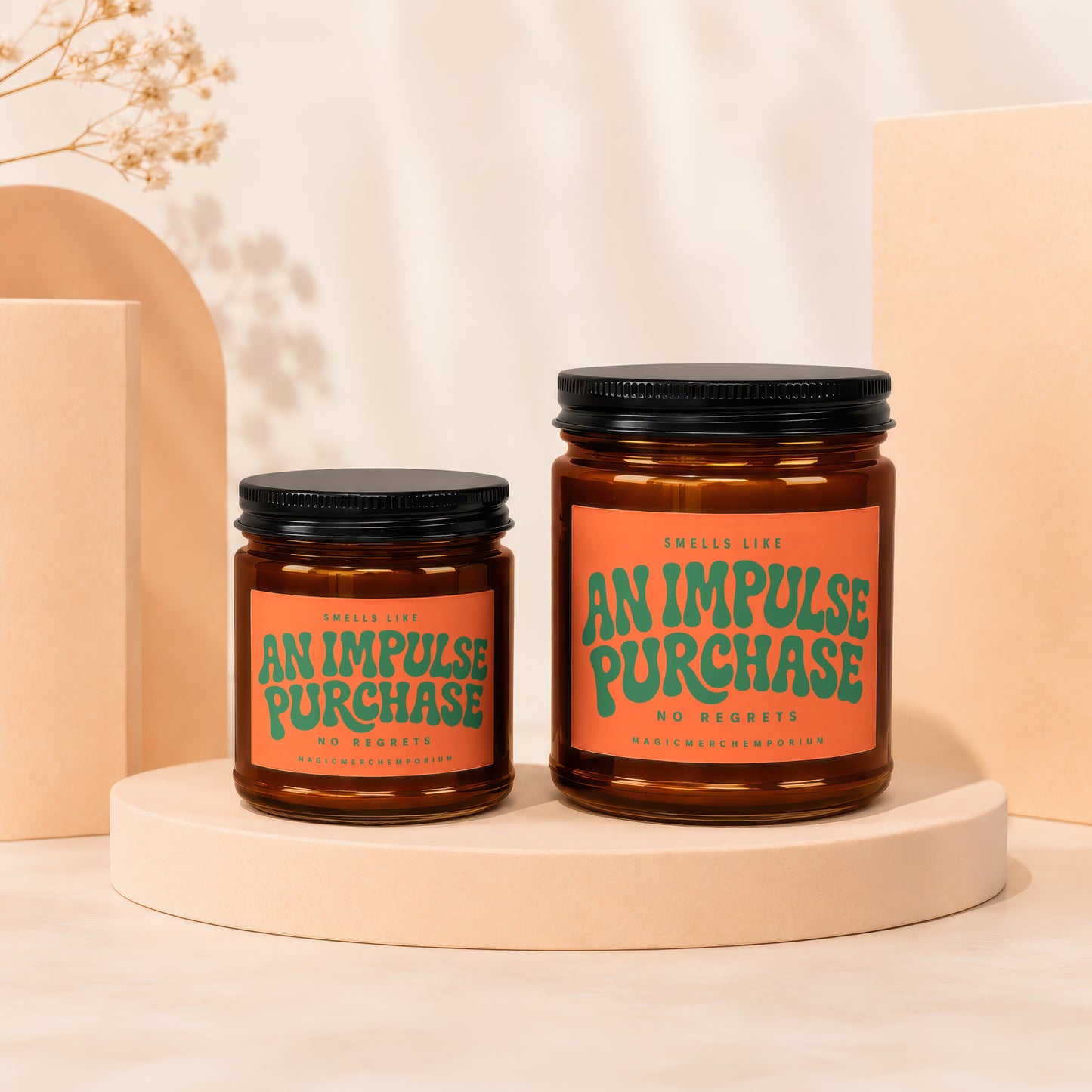 Two amber glass candles with orange labels reading "An Impulse Purchase."