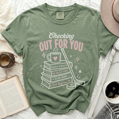Green t-shirt with "Checking Out For You" and book-themed graphics.