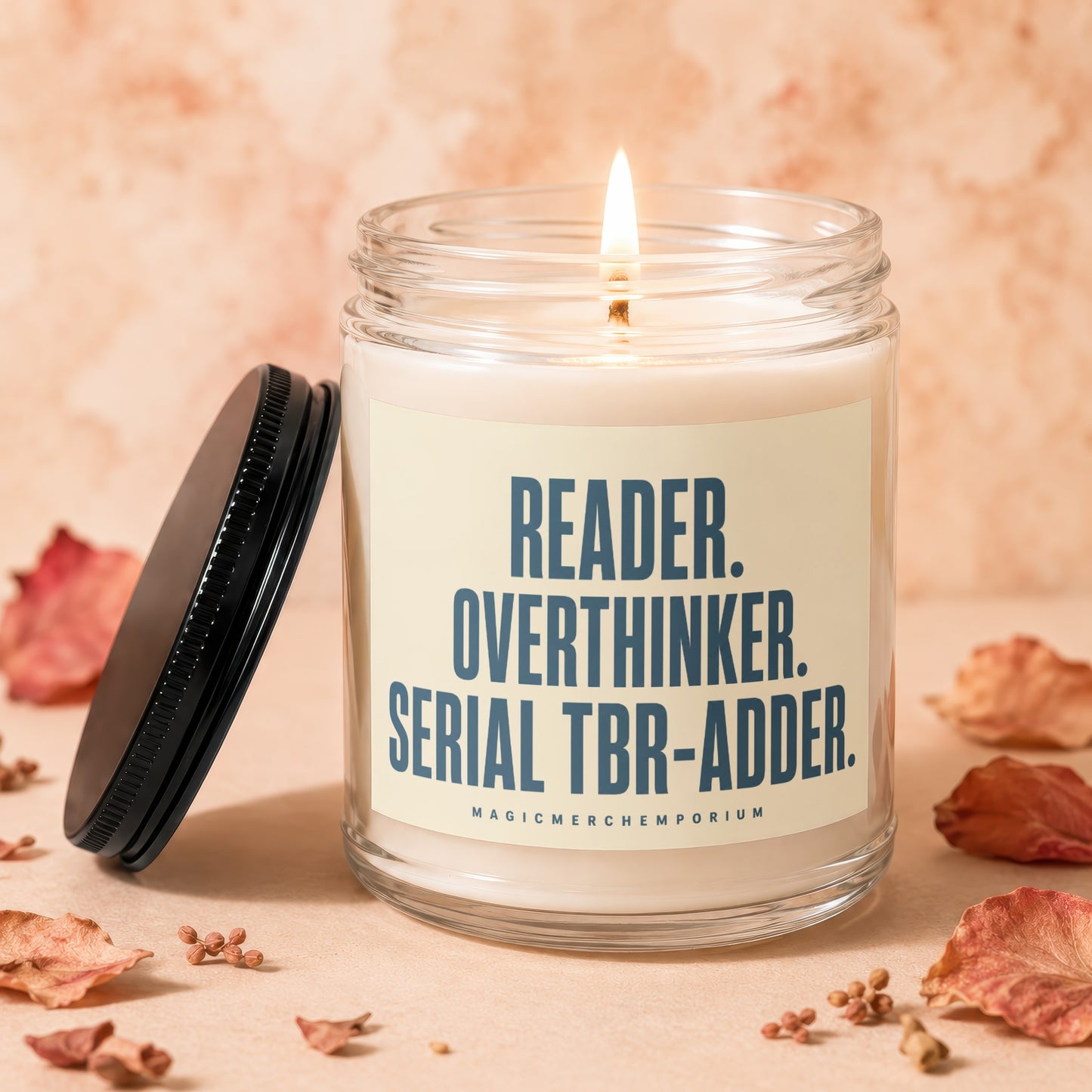 Candle with "READER. OVERTHINKER. SERIAL TBR-ADDER." text and a lit wick.