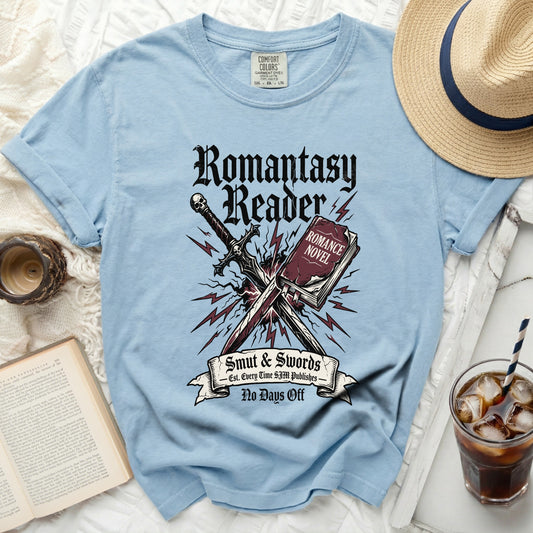 Light blue shirt with "Romantasy Reader Smut & Swords" graphic.