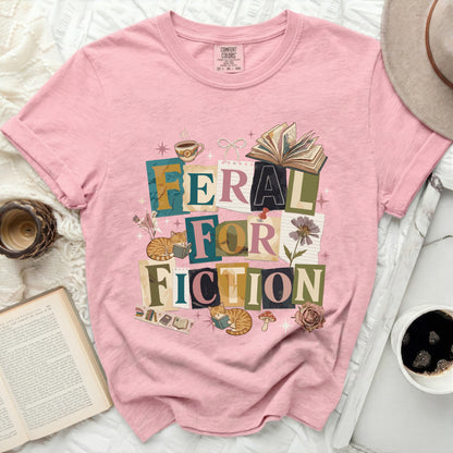 Pink t-shirt with "Feral For Fiction" text and cat illustrations.