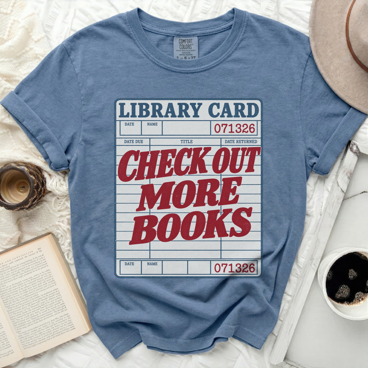 Blue t-shirt with "Library Card" graphic and "Check Out More Books" text.