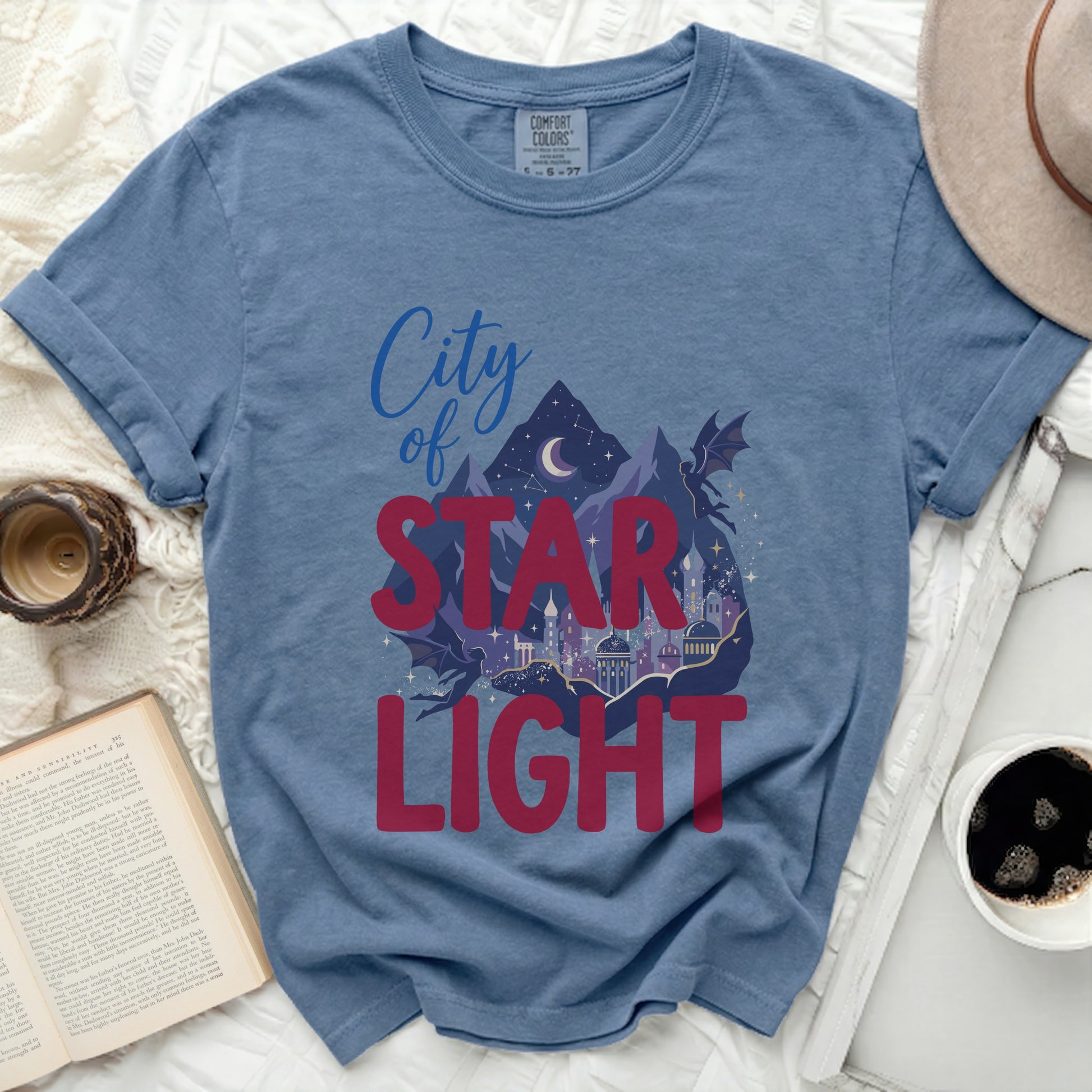 Blue t-shirt with "City of STAR LIGHT" graphic featuring a city, mountains, and dragons.