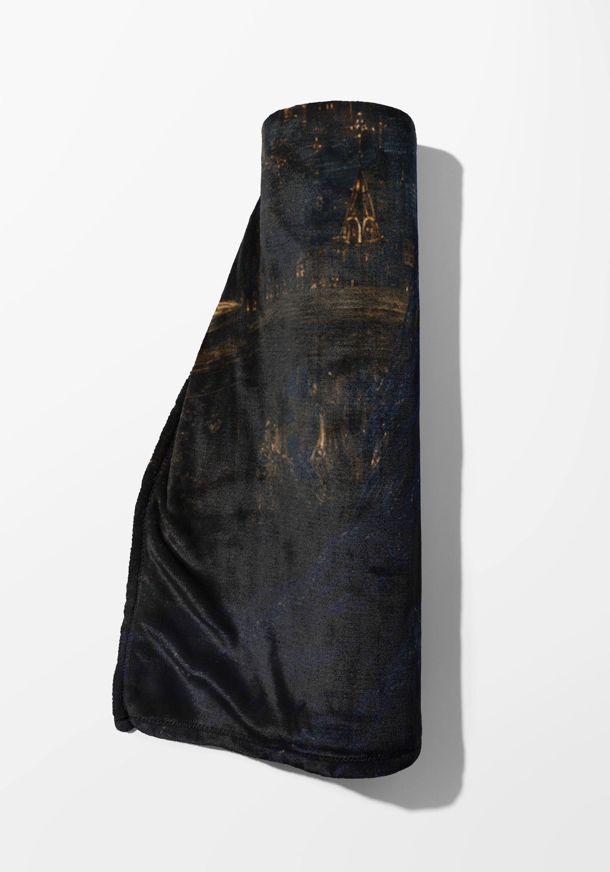 Dark rolled blanket with a nocturne cityscape design and golden lights.