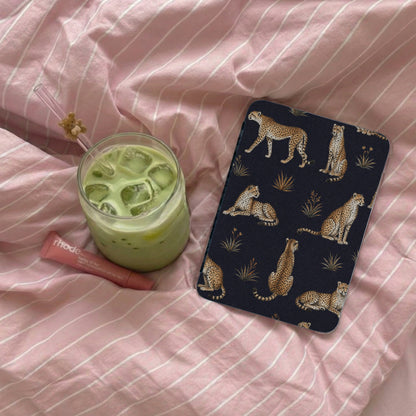 Dark blue case with a leopard print pattern on pink striped bedding.