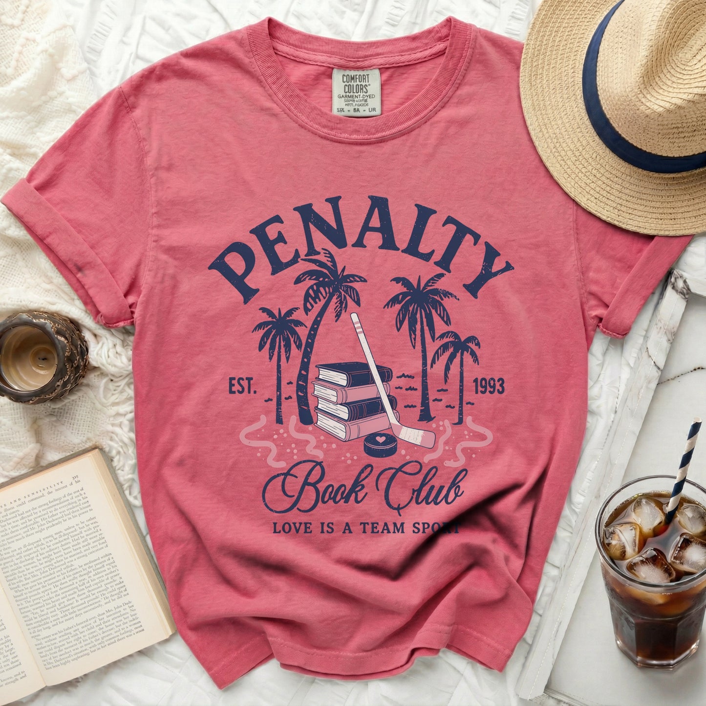 Pink t-shirt with "Penalty Book Club" and hockey sticks.