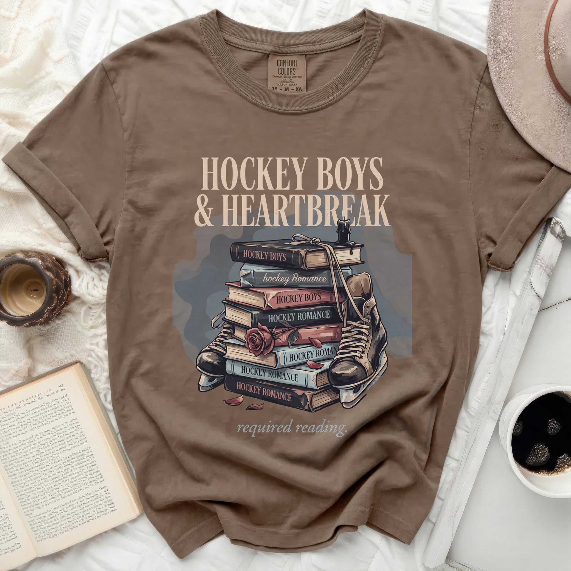 T-shirt with stacked books, roller skate, and "Hockey Boys & Heartbreak" text.