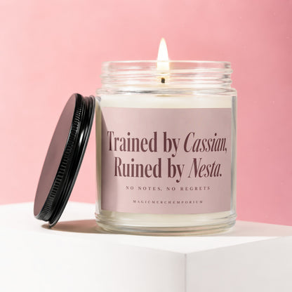 Candle with pink label that reads "Trained by Cassian, Ruined by Nesta."