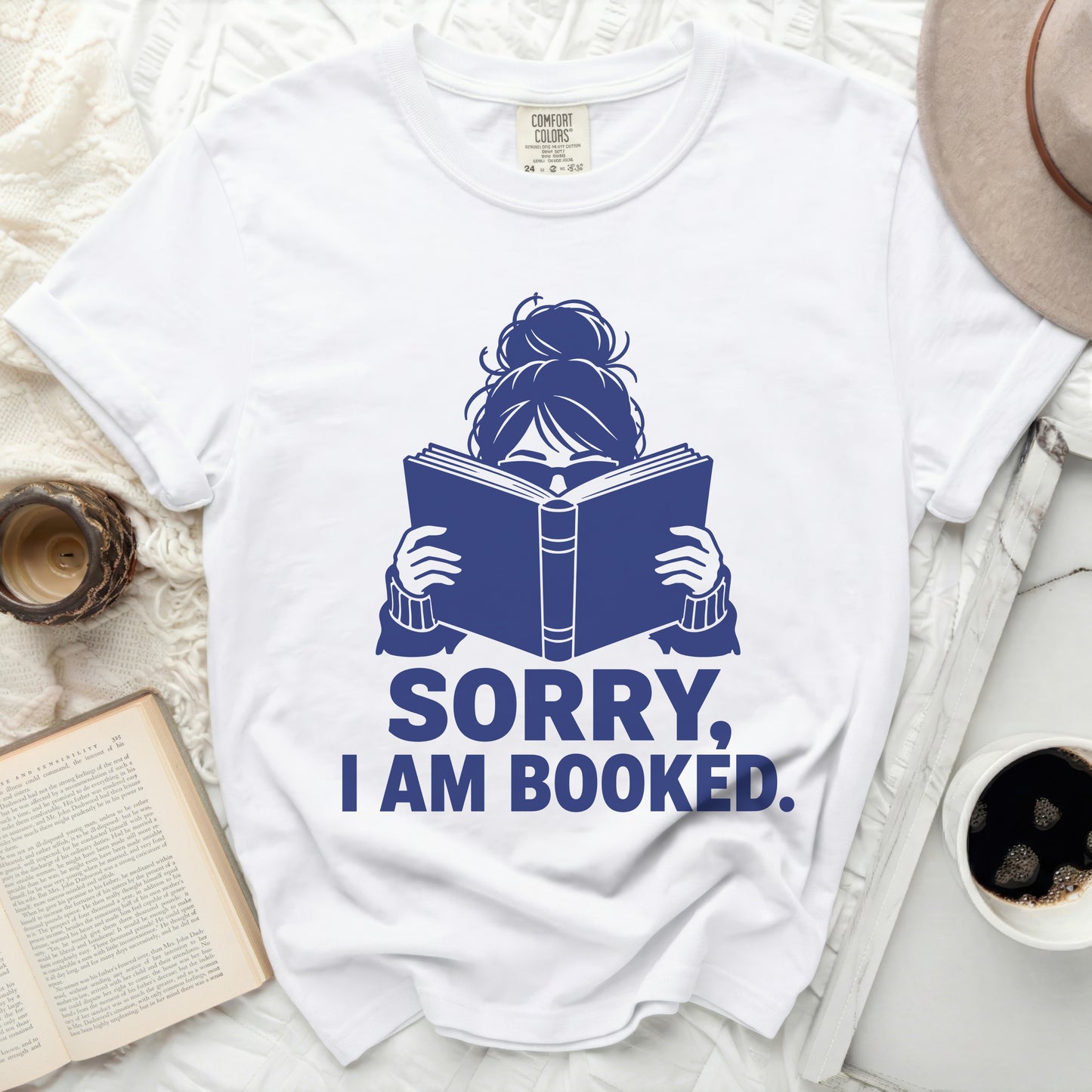 White t-shirt with "SORRY, I AM BOOKED." text and book icon.