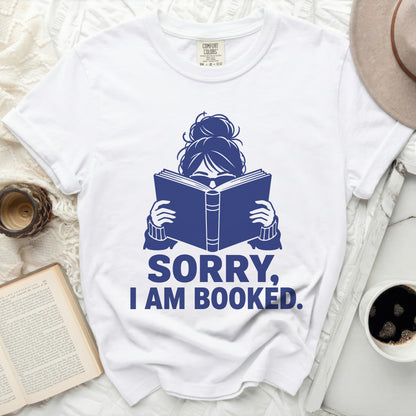 White t-shirt with "SORRY, I AM BOOKED." text and book icon.