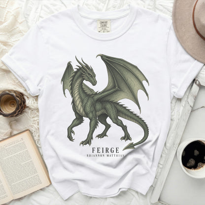 White t-shirt with a green dragon graphic and the text "FEIRGE RHIANNON MATTHIAS".