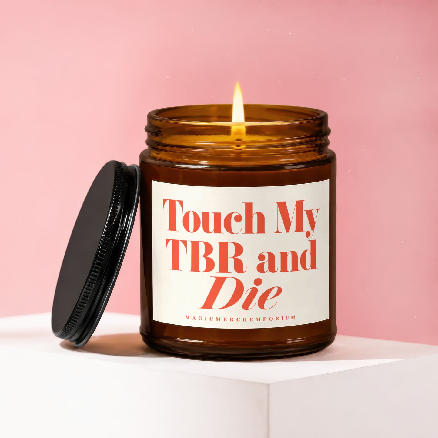 Amber jar candle with lit flame and lid removed, reads "Touch My TBR and Die".