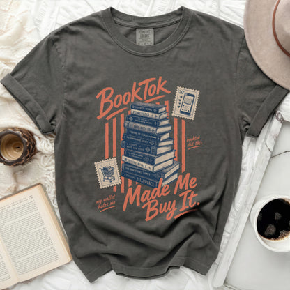 Grey t-shirt with "BookTok made me buy it" and stacked book titles.
