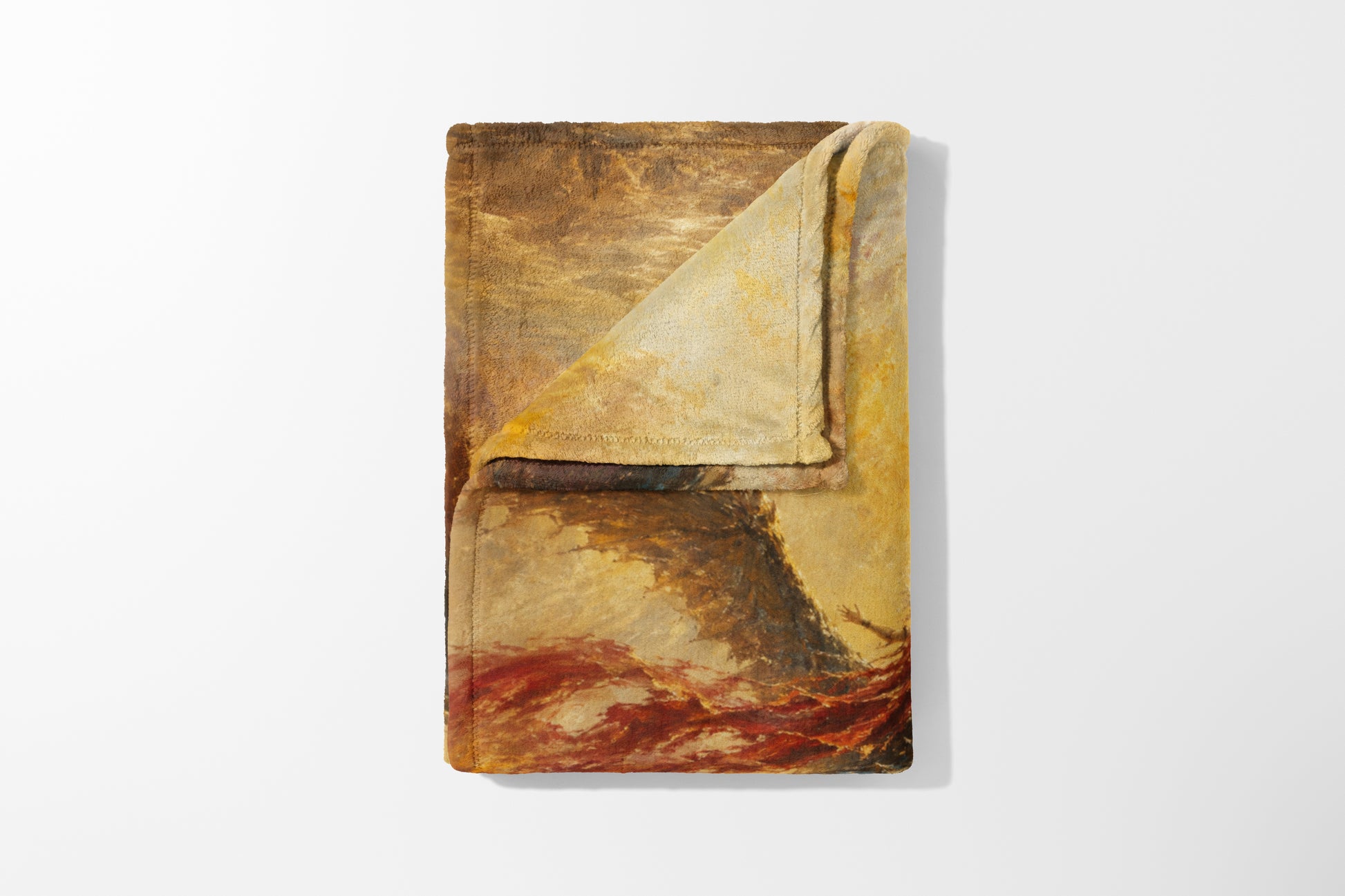 Folded towel with a dramatic painting of a ship in a stormy sea and coral reef.