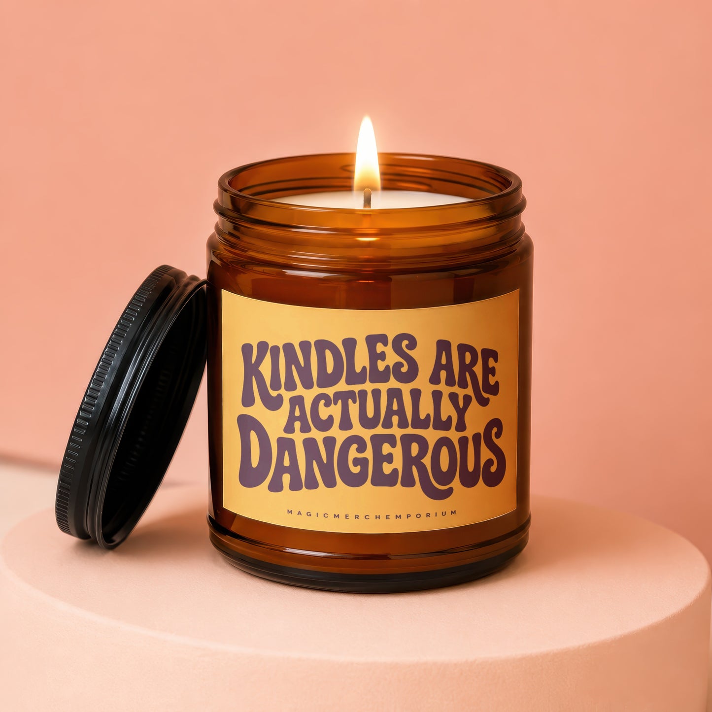 Candle in amber jar with lid off, saying "KINDLES ARE ACTUALLY DANGEROUS."