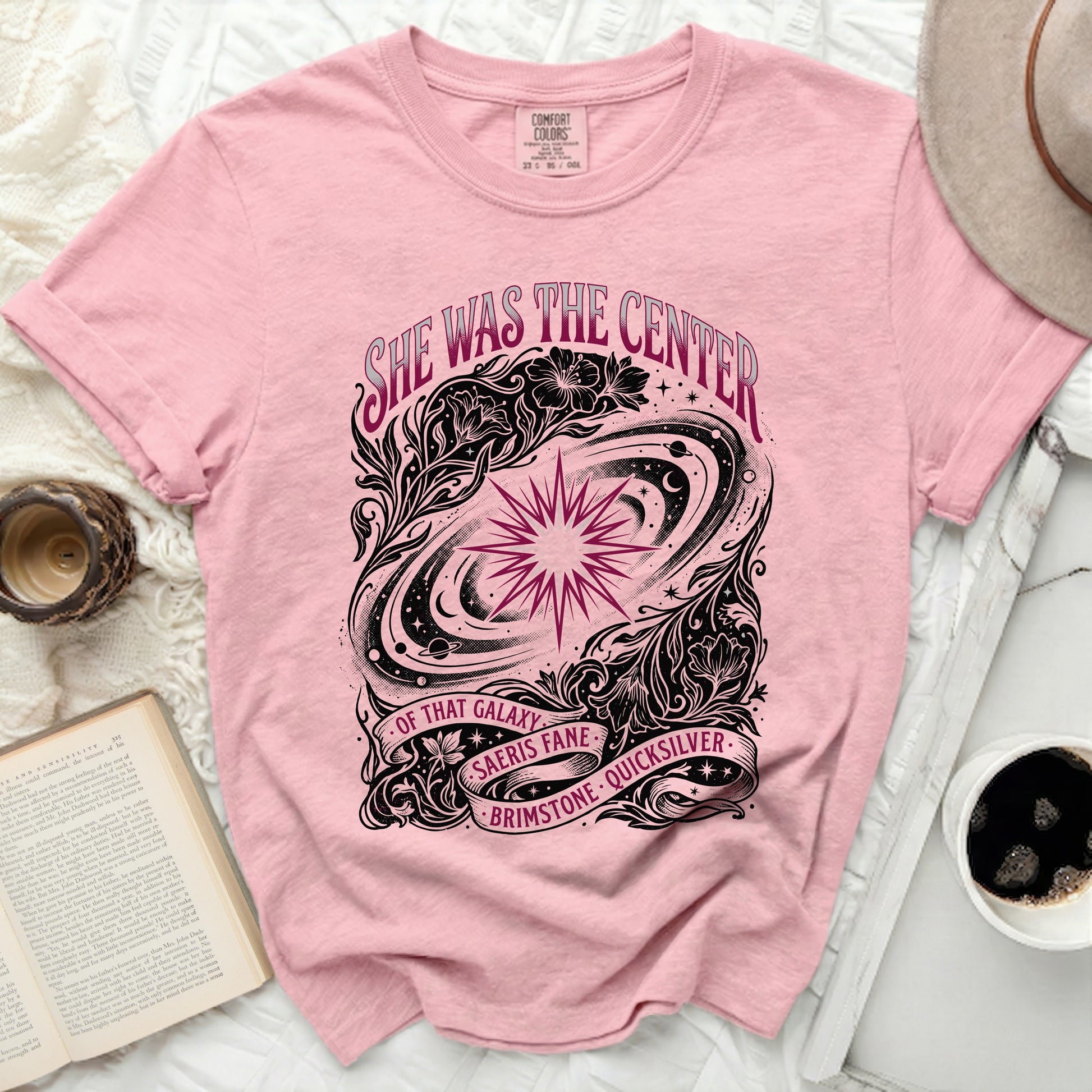 Pink t-shirt with "She was the center of that galaxy" text and celestial design.