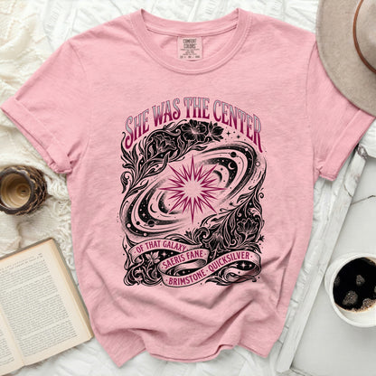 Pink t-shirt with "She was the center of that galaxy" text and celestial design.