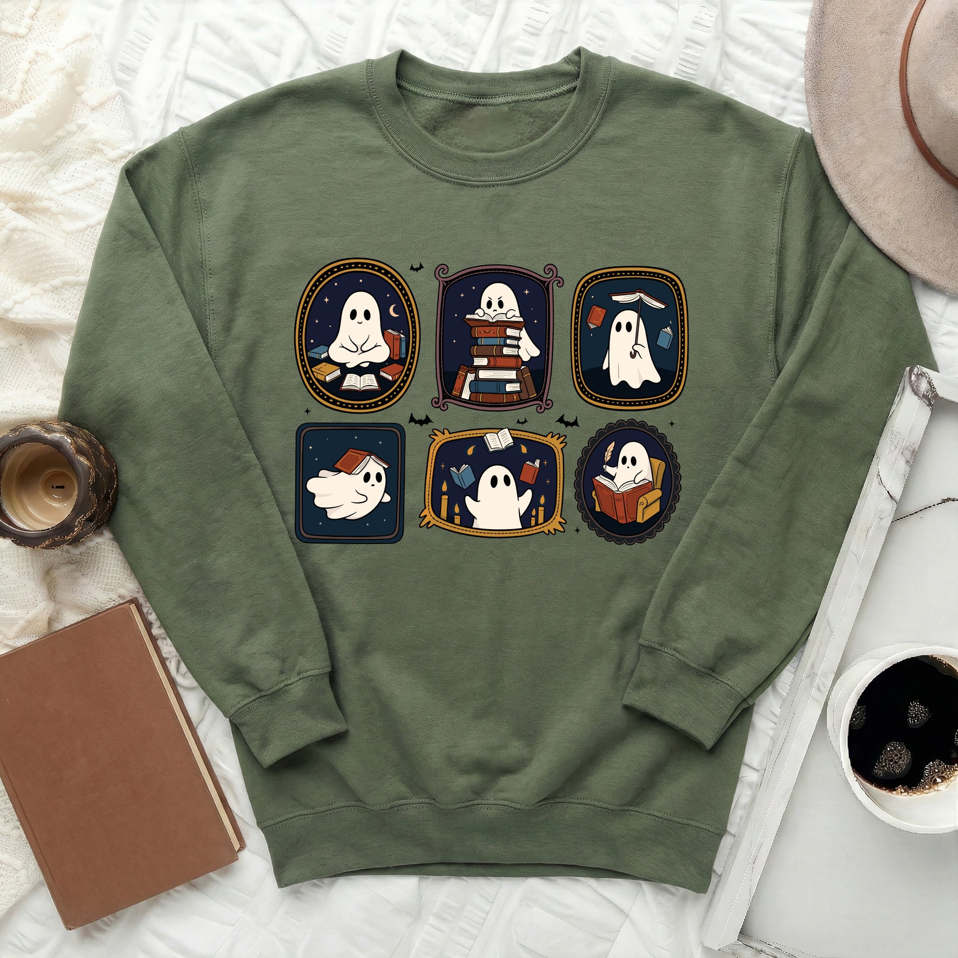 Green sweatshirt with five framed illustrations of cute ghosts reading books.