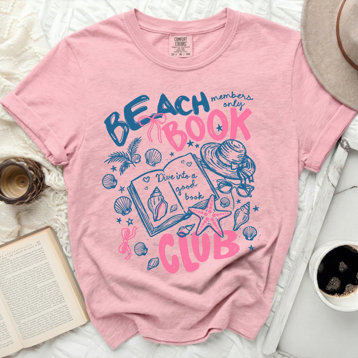 Pink t-shirt with "Beach Book Club" text and beach icons.