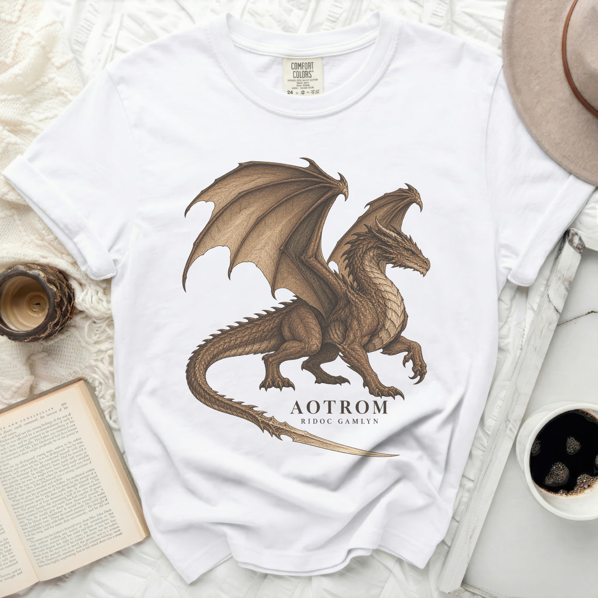 White t-shirt with a brown dragon graphic and text "AOTROM RIDOC GAMLYN".