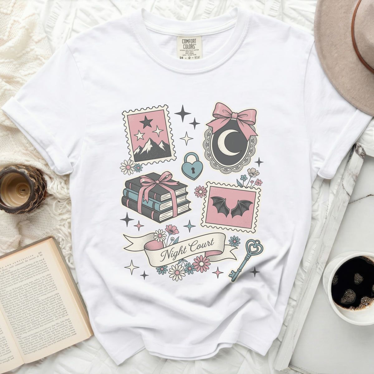 White t-shirt with graphic design of stamps, moon, bats, books, and "Night Court" text.
